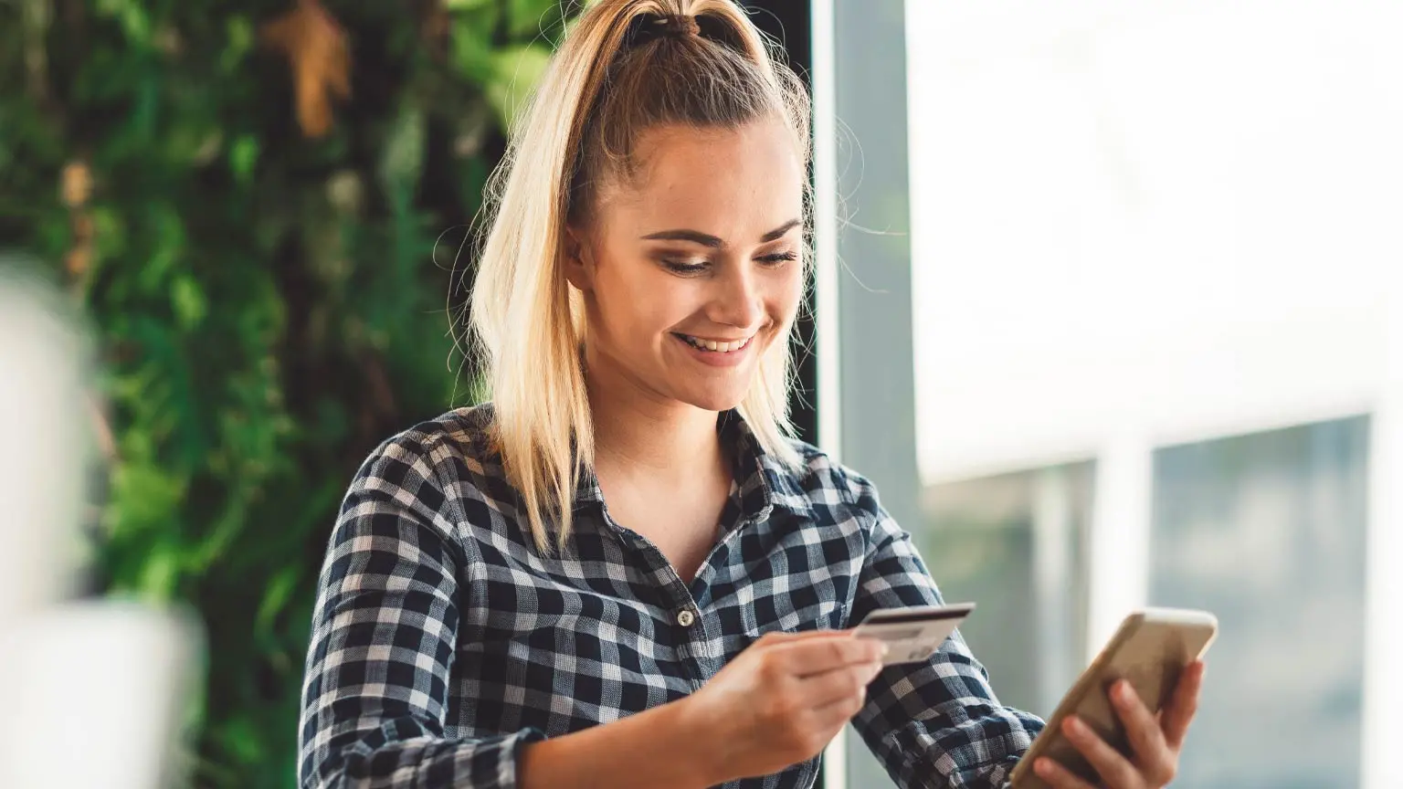 Junge Frau mit Kreditkarte und Handy