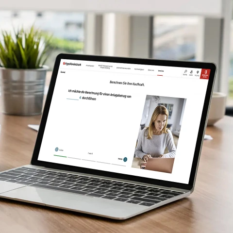 Laptop auf Holztisch zeigt Webseite der HypoVereinsbank mit Rechner für Kaufnebenkosten.