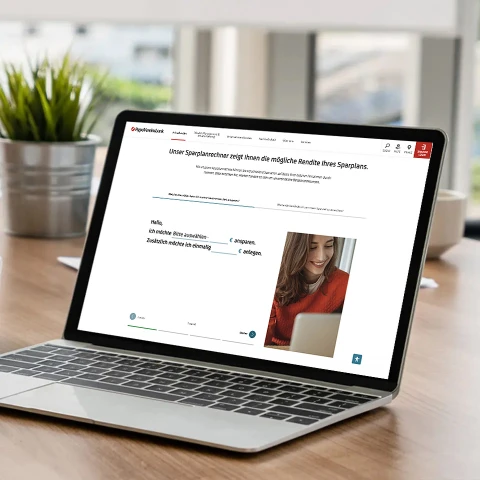 Laptop auf Holztisch zeigt Webseite der HypoVereinsbank mit Rechner für Sparziele.