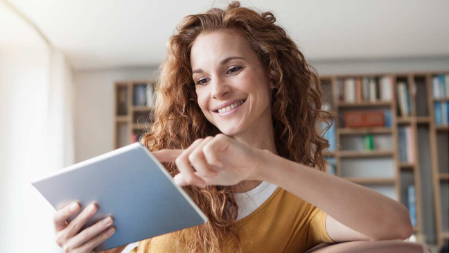 Lächelnde junge Frau mit Tablet