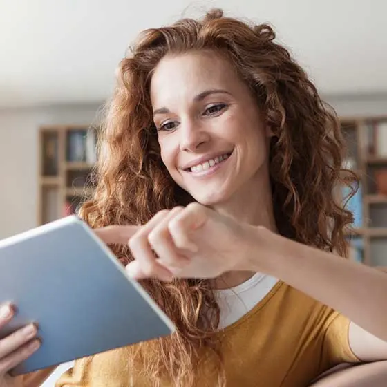 Lächelnde junge Frau mit Tablet