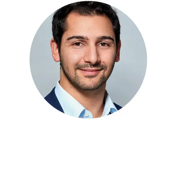 Porträt einer Person mit Glatze und Anzug in einem runden Bildausschnitt vor hellem neutralem Hintergrund.