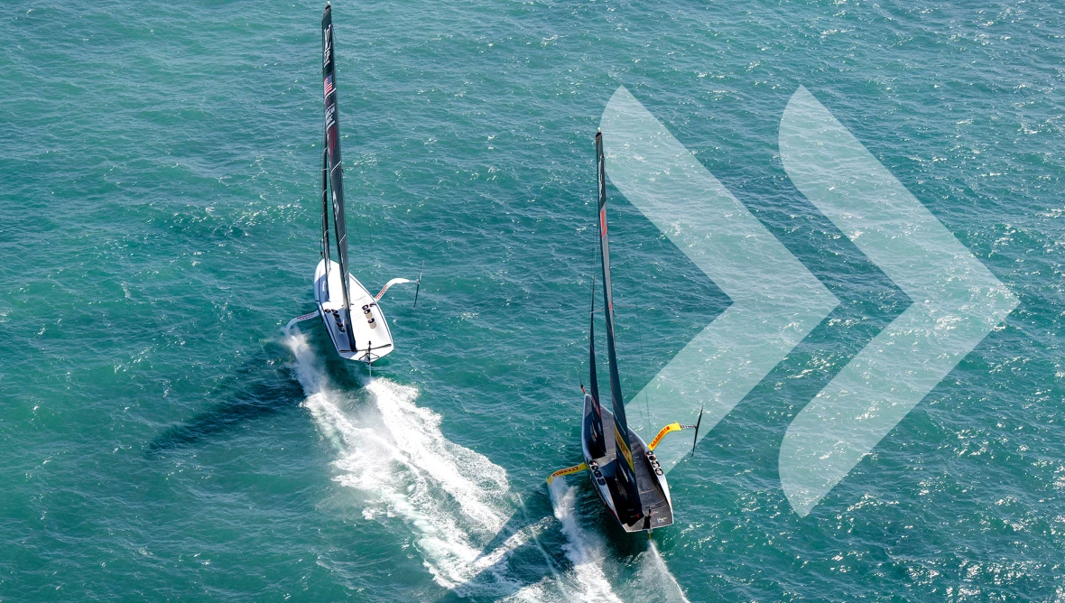 Eine Sicht von oben auf zwei Sport-Segelschiffe auf dem Wasser, ringsum ist nur Wasser zu sehen. Rechts sind zwei durchsichtige Pfeile als Icon auf dem Foto. 