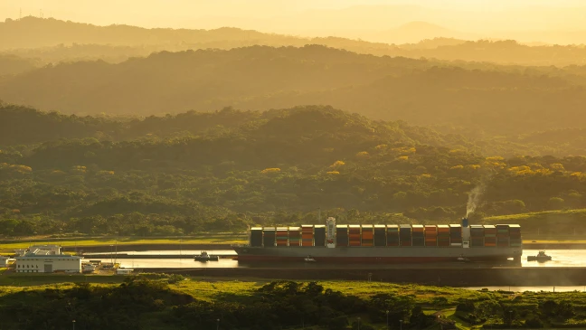 Containerschiff auf Flusslandschaft.