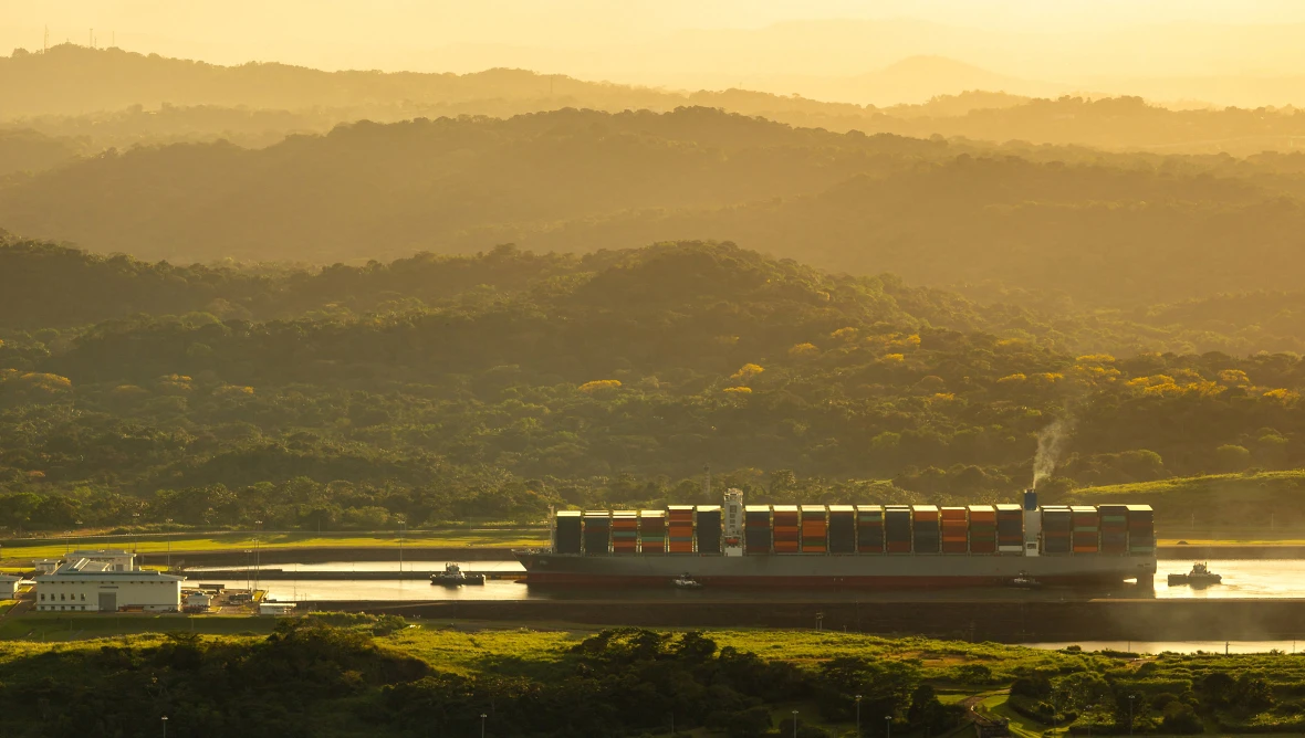 Containerschiff auf Flusslandschaft
