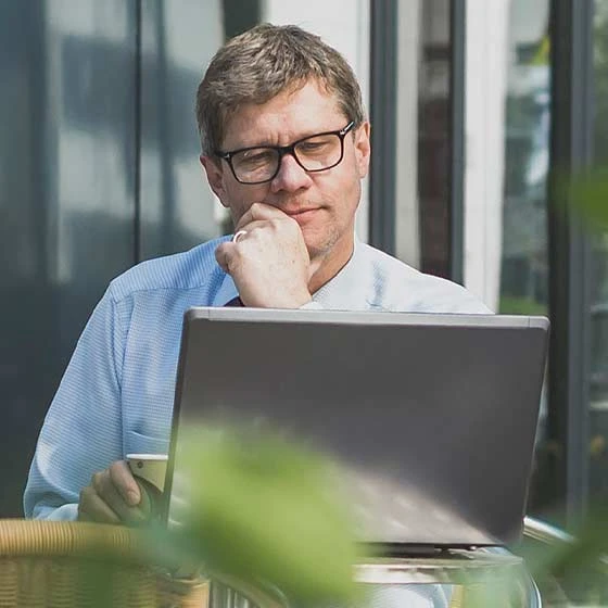 Mann sieht auf Laptop